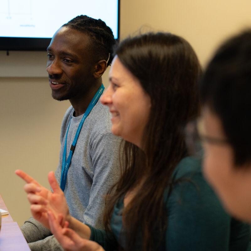 Researcher speaking to group sat around a table