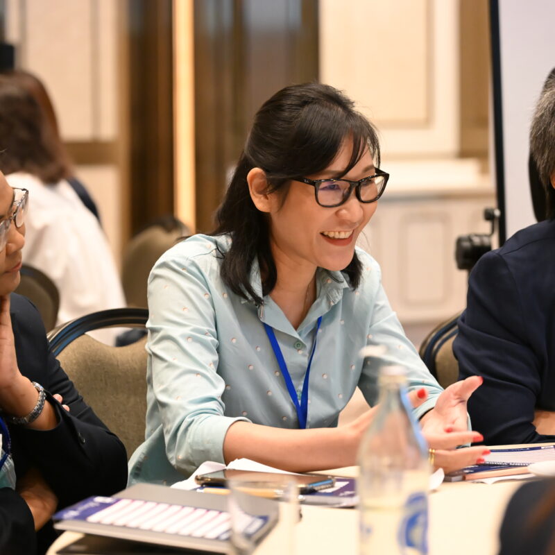 Mahidol University Researcher speaking to table of researchers